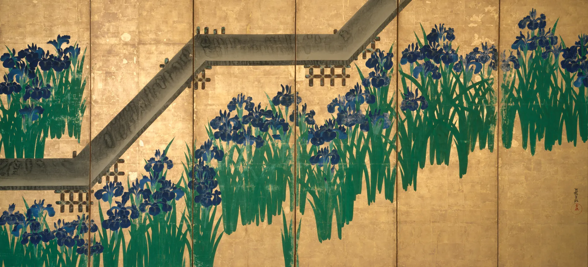 Clumps of deep blue irises with tall green leaves on a ground of gold leaf, crossed by a zigzag plank bridge.